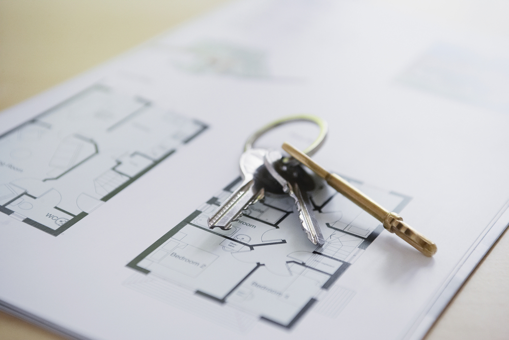 Closeup of keys on blueprint of a home symbolizing qualification in a reverse 1031 exchange investment property